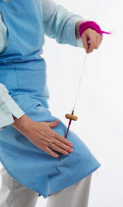 person rolling spindle along their thigh